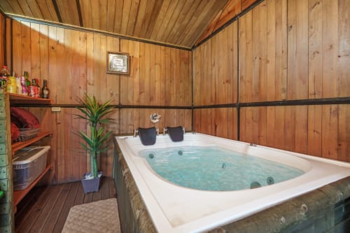 Bañera de lujo en habitación glamping de madera en Sukha Glamping, Rionegro, Colombia con vistas al jardín y amenidades spa