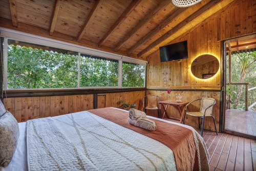 Habitación Eucalipto en Sukha Glamping de Ríonegro con interiores de madera, cama queen, vistas al jardín y comodidades modernas