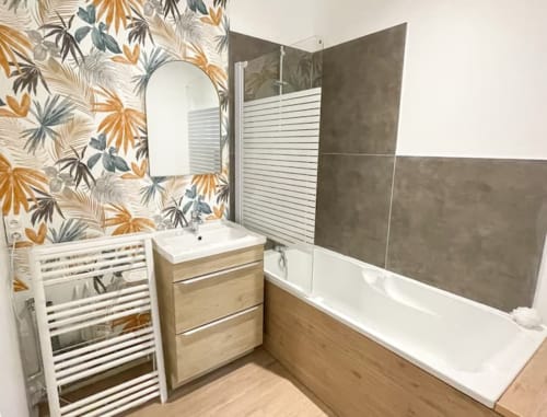 Salle de bains moderne à La Demeure des Cyprès, Alençon avec papier peint tropical, meuble vasque en bois, sèche-serviettes chauffant et douche italienne