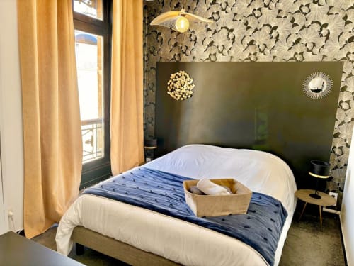 Chambre moderne à l'appartement La Demeure des Cyprès au centre-ville d'Alençon, avec tête de lit foncée et accents dorés