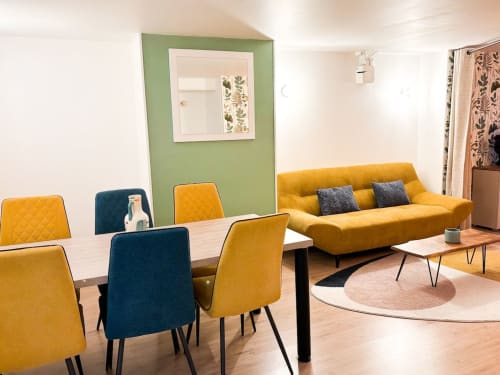 Séjour moderne à La Demeure des Cyprès à Alençon : canapé jaune, table de salle à manger et mur d'accent vert