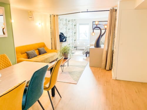 Appartement lumineux à La Demeure des Cyprès à Alençon avec canapé jaune, coin repas et décor contemporain
