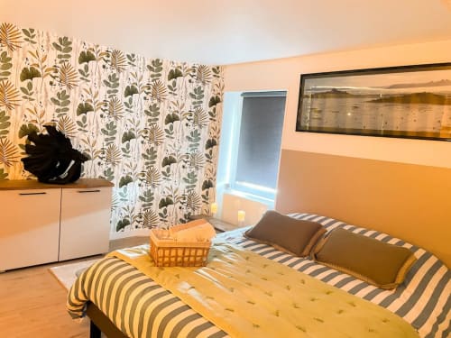 Chambre lumineuse à La Demeure des Cyprès à Alençon avec literie rayée, rideaux botaniques et mobilier contemporain
