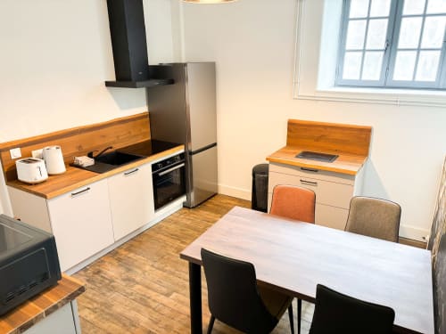 Cuisine et salle à manger luxueuses à La Demeure des Cyprès, Alençon avec comptoirs en bois et appareils modernes