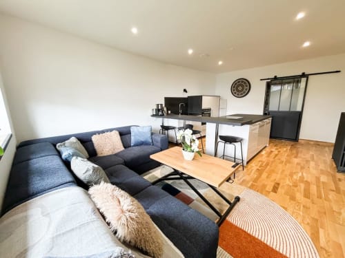 Appartement moderne à La Demeure des Cyprès à Alençon avec canapé sectionnel anthracite, cuisine ouverte et parquet