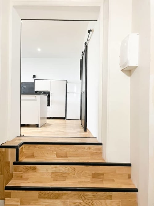Cuisine moderne de l'appartement La Demeure des Cyprès à Alençon, avec meubles blancs et parquet