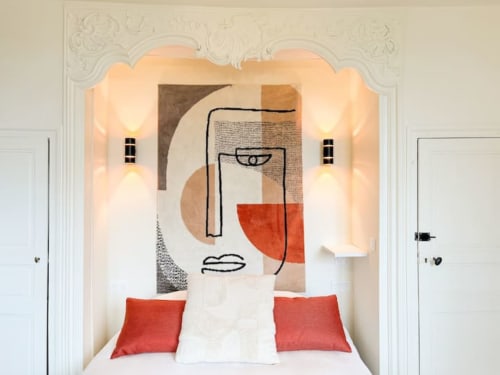 Chambre d'hôtel moderne à La Demeure des Cyprès, Alençon, avec coussins rouges, art mural abstrait et appliques élégantes