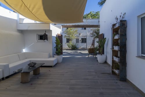 Terraza de Cal Xot B&B en Poble Nou del Delta con muebles blancos, vela de sombra y plantas verdes