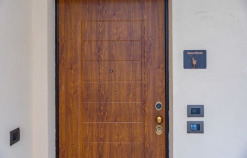 Porta in legno della Villetta Enro Mountain con targa e interruttori elettrici, Roccaraso