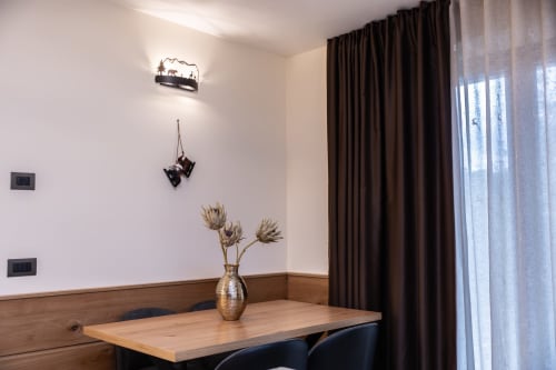 Accogliente camera moderna presso Enro Mountain Vacation Home a Roccaraso con scrivania in legno, fiori secchi e tende scure
