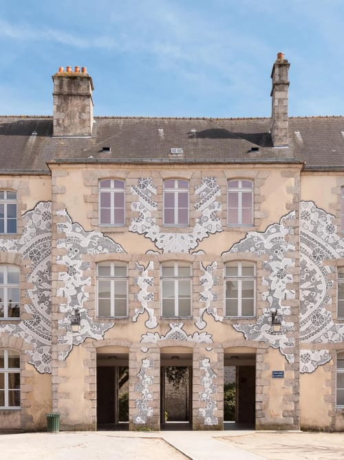 Façade de l'hôtel La Demeure des Cyprès à Alençon avec ses élégantes fresques blanches en motifs de dentelle sur la façade en pierre