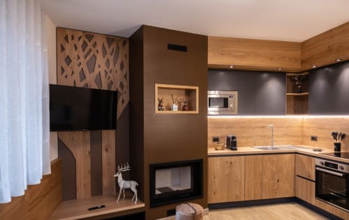 Cucina moderna dell'appartamento di montagna presso Enro Vacation Home a Roccaraso con mobili in legno, camino e TV