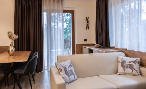 Appartamento Cervo Reale presso Enro Mountain Vacation Home a Roccaraso con divano color crema, zona pranzo e vista sulle montagne