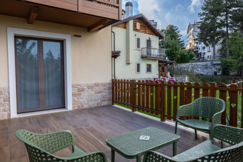 Terrazza dell'appartamento Abete Bianco presso Enro Mountain Vacation Home a Roccaraso con arredi verdi e vista sulle montagne