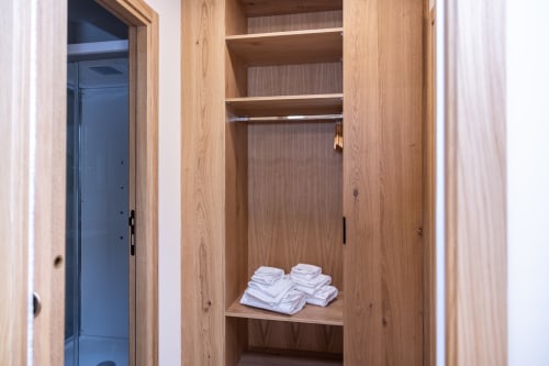 Armadio in legno con asciugamani bianchi presso l'Enro Mountain Vacation Home a Roccaraso