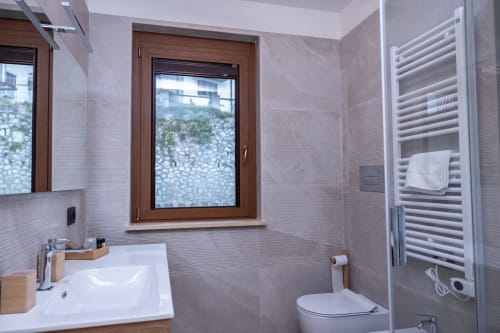 Bagno moderno nell'appartamento Abete Bianco di Enro Mountain Vacation Home, Roccaraso con lavabo bianco, wc e scaldasalviette