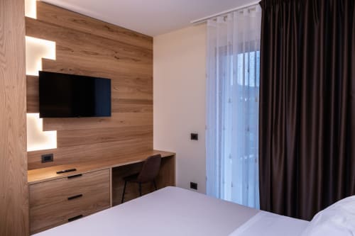 Camera moderna della Enro Mountain Vacation Home a Roccaraso con TV a parete in legno e scrivania di lavoro