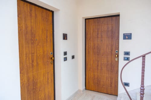 Corridoio della Casa Vacanze Enro Mountain a Roccaraso con due porte in legno e pannelli elettrici