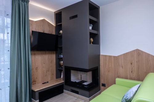 Moderno appartamento a Enro Mountain Vacation Home a Roccaraso con camino, TV integrata, accenti in legno e sedute verdi