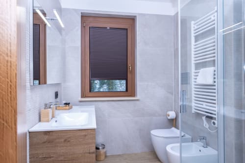 Moderno bagno della Enro Mountain Vacation Home a Roccaraso con vanity in legno, scaldasalviette e box doccia