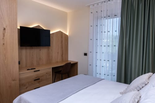 Camera moderna presso Enro Mountain Vacation Home a Roccaraso con scrivania in legno, TV a parete e arredi alpini