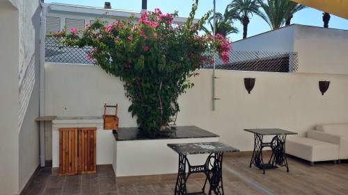 Patio de Cal Xot B&B en Poble Nou del Delta con buganvilias en flor, zonas de descanso y bases de mesa de coser vintage