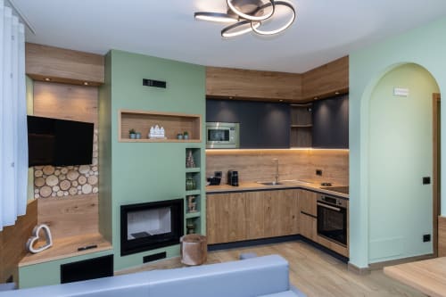 Cucina moderna e zona living della Enro Mountain Vacation Home a Roccaraso con pareti verde menta, mobili in legno e