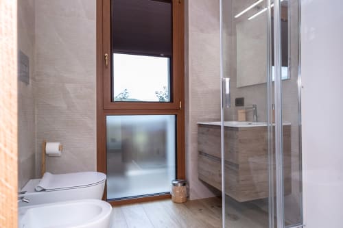 Bagno moderno presso l'Enro Mountain Vacation Home a Roccaraso con wc, lavandino, box doccia e finestra