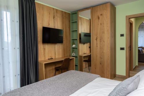 Camera moderna della Enro Mountain Vacation Home a Roccaraso con scrivania in legno incorporata, TV e pareti verde salvia