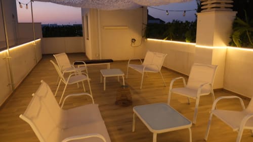 Lounge en la azotea de Cal Xot al atardecer con asientos cómodos, iluminación ambiental y vistas a Poble Nou del Delta