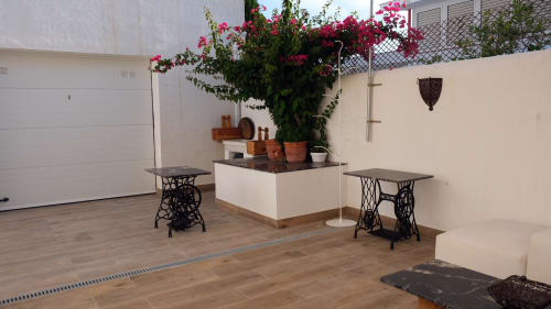 Patio de Cal Xot en Poble Nou del Delta con buganvilia en flor, mesas antiguas y macetero de piedra