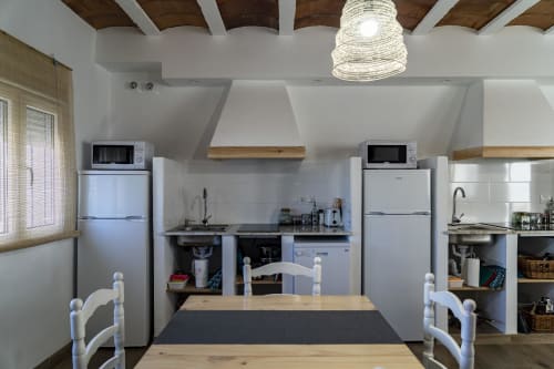 Cocina de Cal Xot BnB en Poble Nou del Delta con electrodomésticos modernos, vigas de madera y comedor