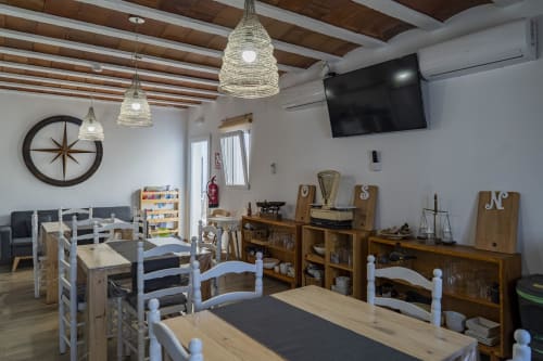 Comedor de Cal Xot con mesas de madera, lámparas colgantes tejidas y decoración rústica en Poble Nou del Delta