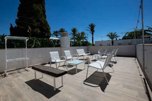 Terraza en la azotea de Cal Xot B&B en Poble Nou del Delta con tumbonas y palmeras bajo cielo despejado