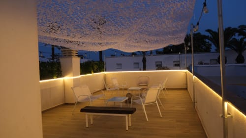 Terraza en azotea de Cal Xot BnB al atardecer con zona de estar, luces decorativas y vistas al delta en Poble Nou, España