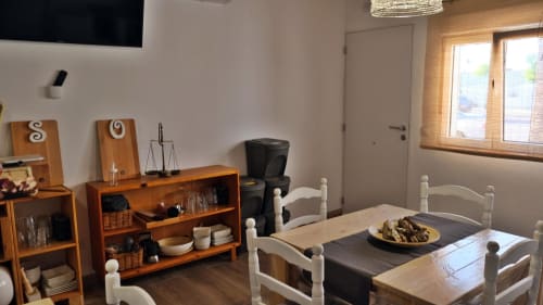 Zona de comedor de Cal Xot BnB en Poble Nou del Delta con muebles de madera, sillas blancas y decoración de balanza