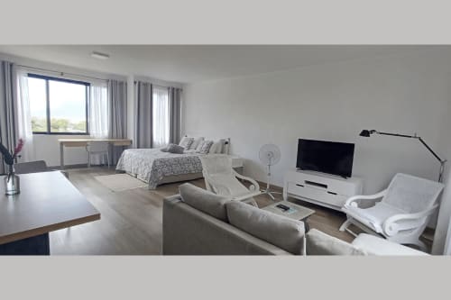 Modern studio apartment at Joubarbe Résidence in Moka with mountain view, furnished with bed, sofa, desk, and TV
