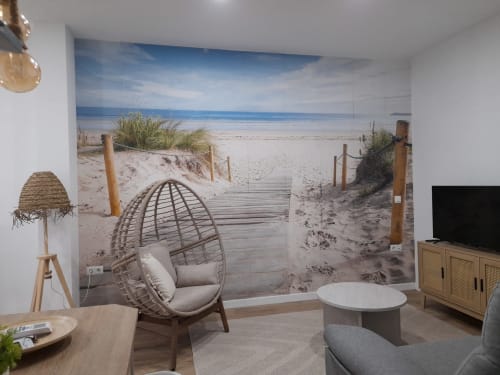 Modern apartment living room with beach-themed mural, hanging egg chair, and TV at G&H Apartments Jerez de la Frontera