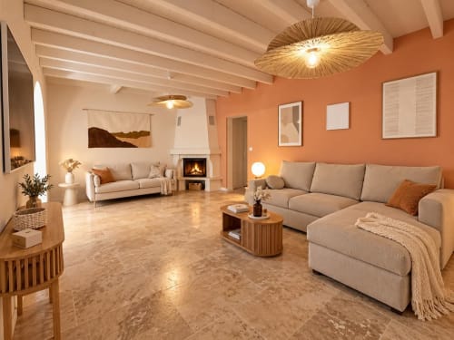 Salon chaleureux aux Nuits d'audace, Alès avec canapés beiges, cheminée, murs terracotta et plafond en bois