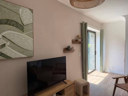 Salon moderne du Clos de l'Arguenon aux murs roses, avec écran plat et portes-fenêtres donnant sur