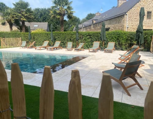 Piscine du Clos de l'Arguenon avec transats et cottages en pierre à Val-d'Arguenon