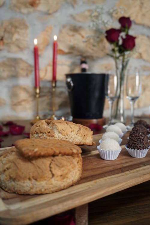 Élégant plateau de desserts à Recantos D'Almerinda à Pombal avec biscuits, chocolats, bougies et roses