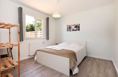 Bright bedroom in Rome Apartment at Résidence des Sables, Mably, with white bed, wooden loft, terrace view, and modern