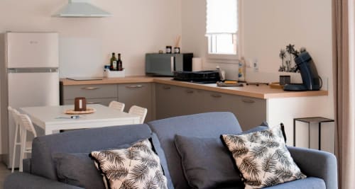 Modern studio apartment in Mably with gray sofa, open kitchen, dining area, and contemporary furnishings