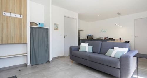 Modern Rome Apartment living area at Résidence des Sables, Mably with gray sofa and open-plan kitchen