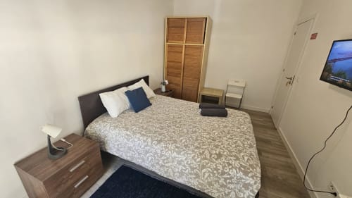 Quarto espaçoso na pousada Lisboa com cama queen, criado-mudo, TV, guarda-roupa em madeira e piso em parquet na casa de hóspedes em Amadora
