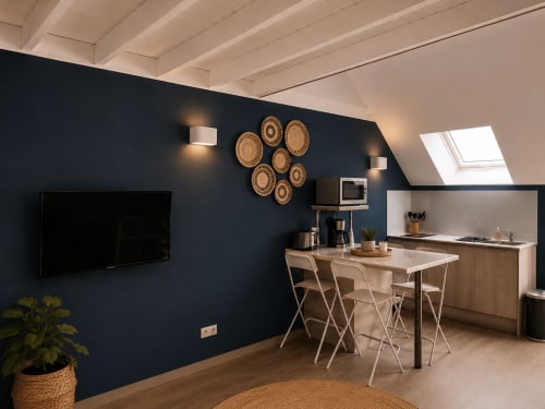 Cuisine et salle à manger modernes à La Parenthèse Mancelle au Mans avec mur d'accent bleu marine, table en bois et tissage