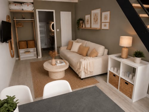 Petit studio douillet à La Parenthèse Mancelle au Mans avec canapé crème, touches de bois et décoration neutre