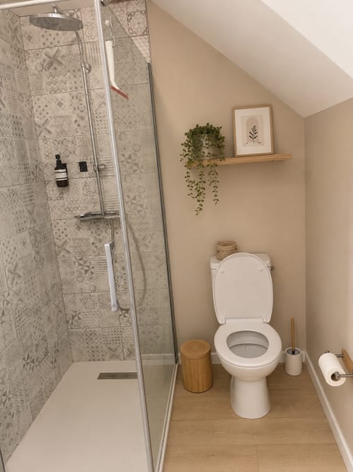 Salle de bains moderne de l'appartement L'Écrin minéral à La Parenthèse Mancelle, Le Mans avec douche italienne, toilettes et décoration végétale