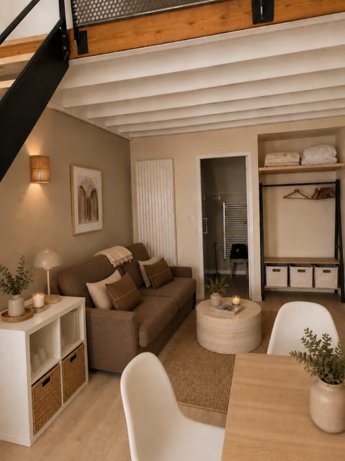Studio cosy à La Parenthèse Mancelle au Mans avec canapé marron, poutres apparentes et équipements modernes